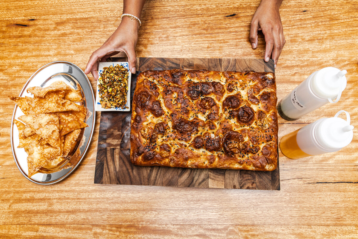 A golden focaccia slab on a wooden board