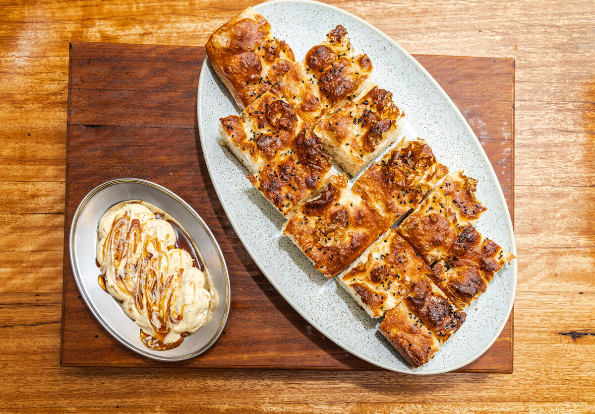 Focaccia slices and dessert plated on a wooden board