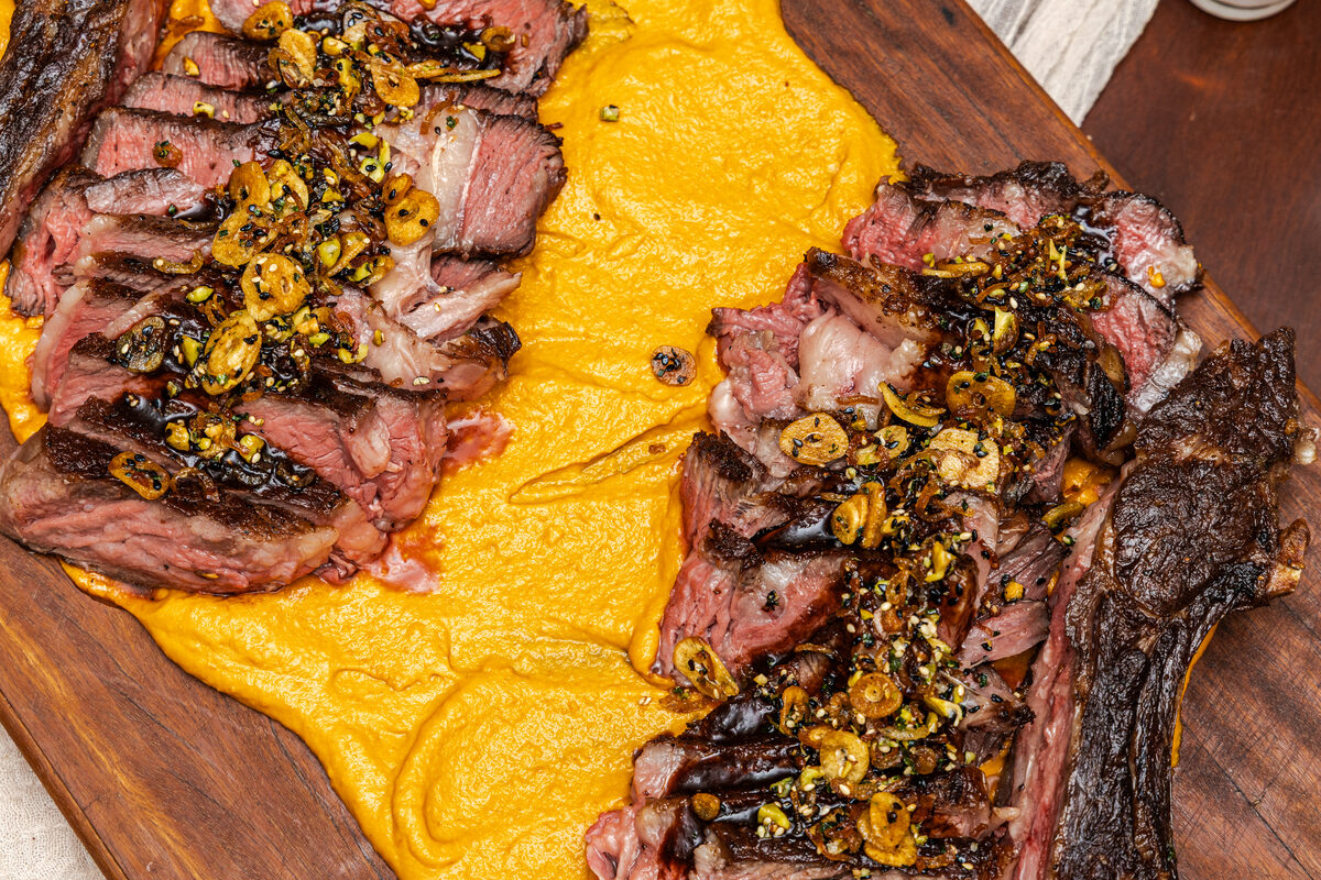 Close-up of sliced steak over golden purée